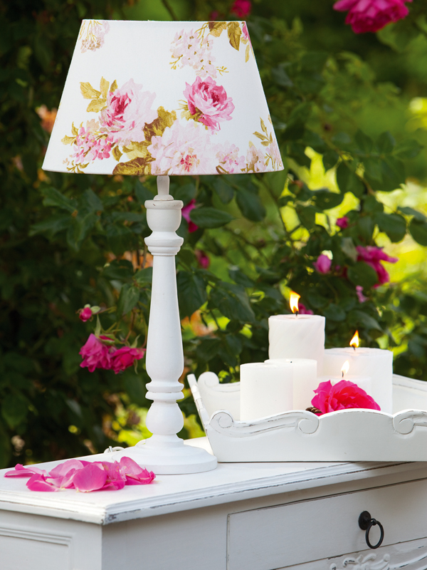Romantika v podobě květinové stolní lampy a hořících svíček na komodě